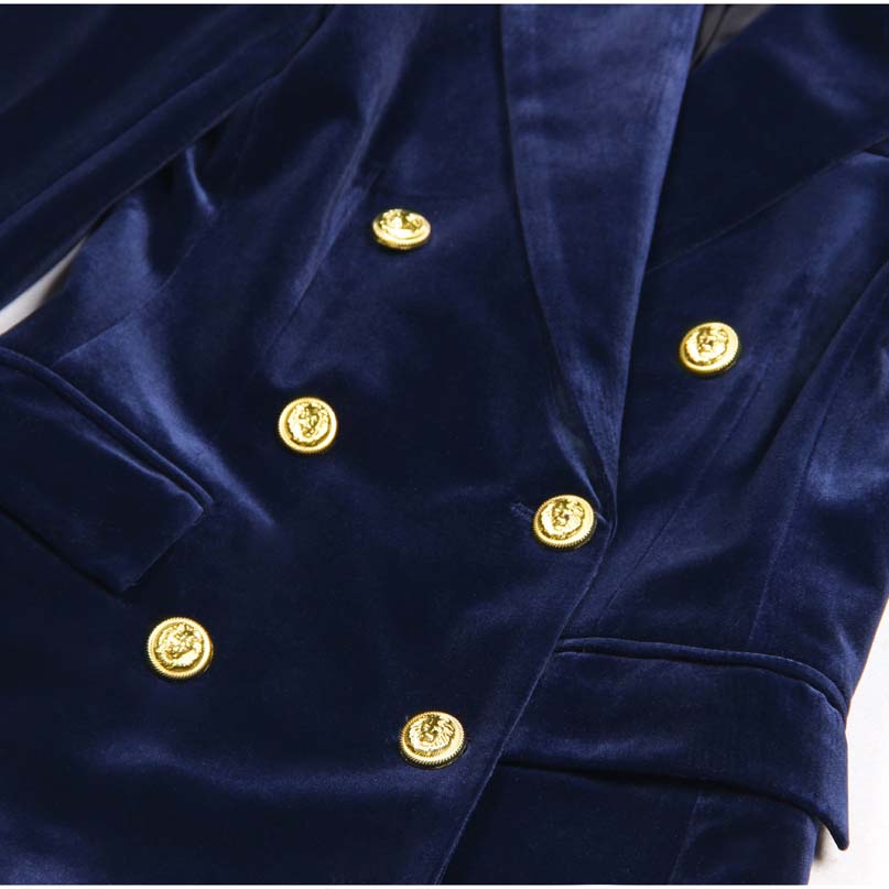 Close-up of a double breasted velvet pantsuit featuring gold buttons and a luxurious navy fabric