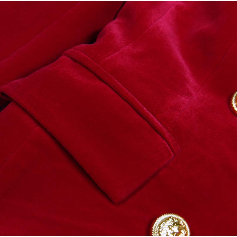 Close-up of a red double breasted velvet pantsuit showcasing luxurious fabric and ornate buttons