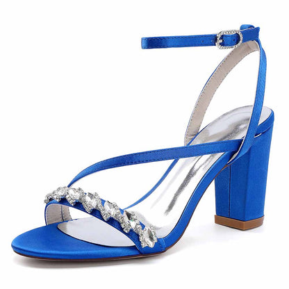 Elegant ankle strap dress shoes in blue satin with jewel embellishments and a chunky heel