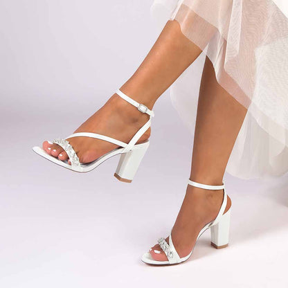 Elegant ankle strap dress shoes in white with decorative details and block heels for stylish occasions
