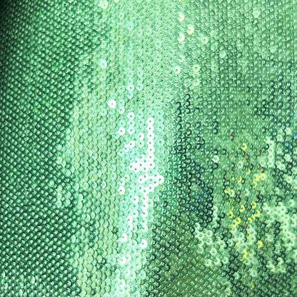 Close-up of emerald green sequin fabric highlighting the sparkle in an emerald green sequin pantsuit for women