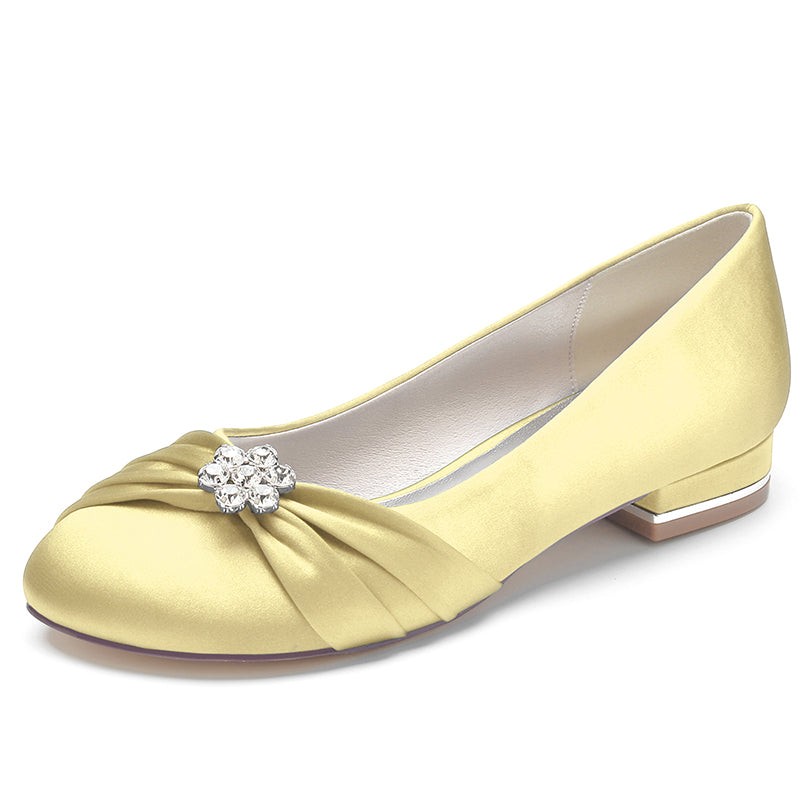 Yellow shoe with a decorative clasp on a white background