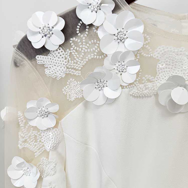 Floral embellished formal gown with intricate white flower details on the shoulder for elegant occasions