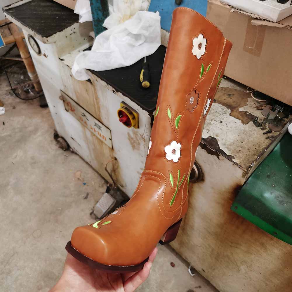 Brown floral embroidered boots with vibrant flower designs and a chunky heel