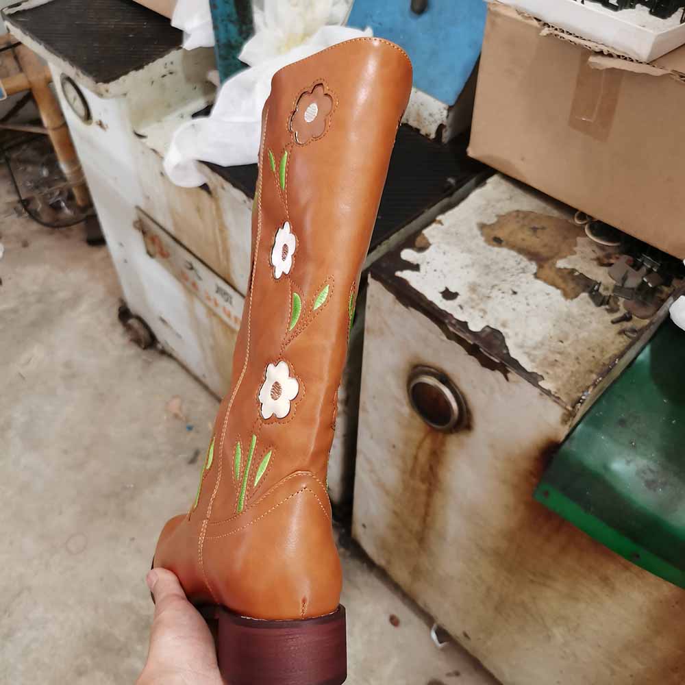 Tan floral embroidered boots featuring vibrant flower designs and a sturdy heel