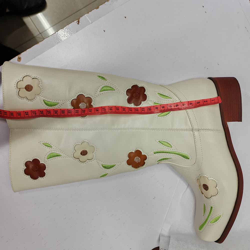 Stylish floral embroidered boots in cream color with colorful floral designs on the shaft