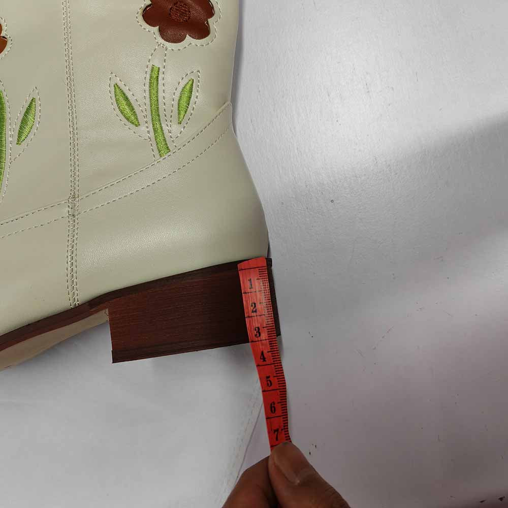 Floral embroidered boots with a cream exterior and detailed flower design on the shaft