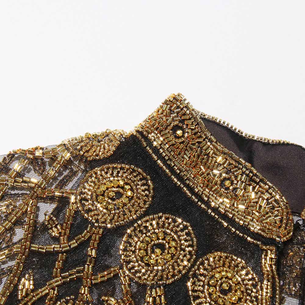 Close-up of a Gatsby style beaded fringe cape with intricate gold beadwork and detailing
