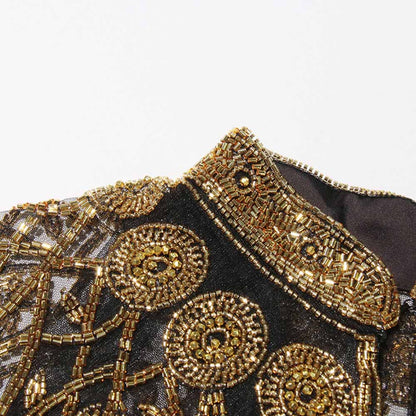 Close-up of a Gatsby style beaded fringe cape with intricate gold beadwork and detailing