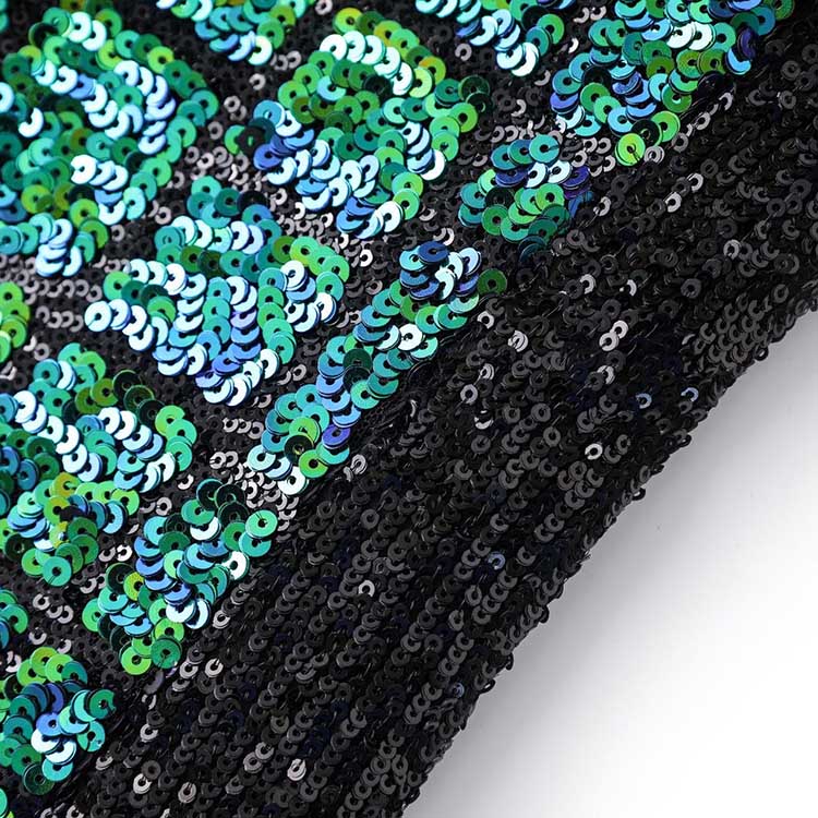 Close-up of a green sequin mini dress showcasing shimmering sequins in varying shades of green and blue