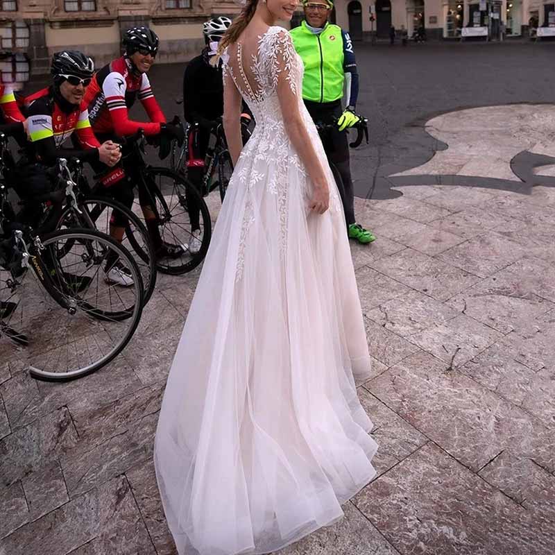 Elegant lace boho wedding dress features open back and flowing skirt, perfect for a romantic wedding day