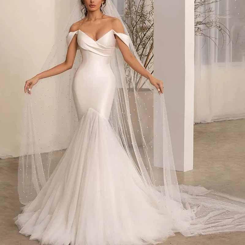 Elegant lace satin off shoulder bridal gown with a fitted silhouette and flowing train