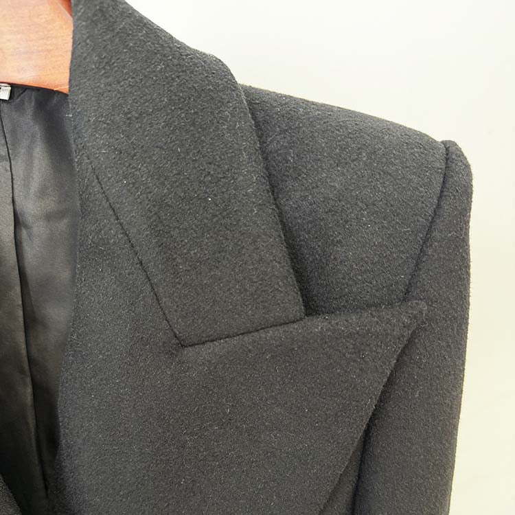 Close-up of a minimalist double-breasted wool coat showing tailored lapels and fine texture