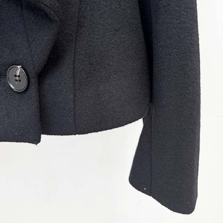 Elegant minimalist double-breasted wool coat featuring a stylish button detail and tailored fit