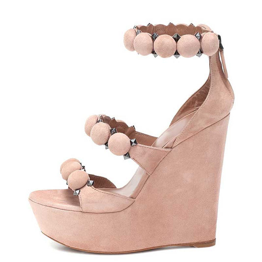 Stylish nude wedge sandals for special occasions featuring decorative pom poms and a high platform design