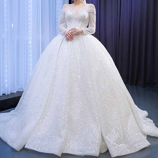 Elegant off the shoulder sequin wedding dress with a full ball gown skirt and long sleeves for a glamorous look