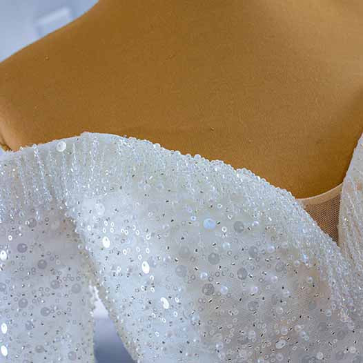 Elegant off the shoulder sequin wedding dress featuring intricate beading and a flattering silhouette