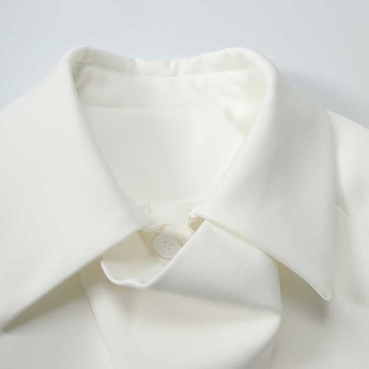 Close-up of off-white belted mini dress with pockets featuring a stylish collar and button detail