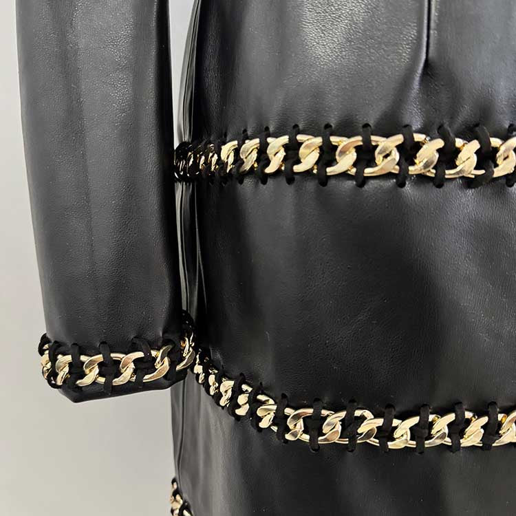 Close-up of one shoulder faux leather mini dress featuring stylish gold chain details