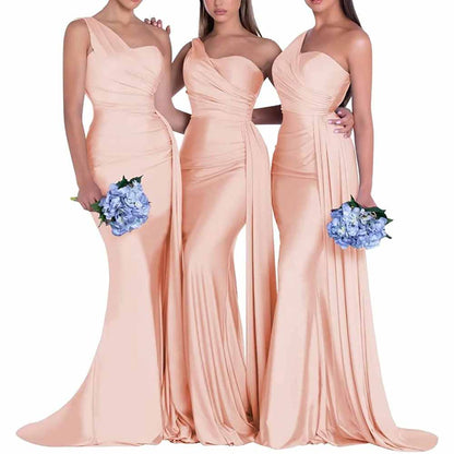 Three elegant one shoulder satin bridesmaid dresses in blush pink with flowing fabric and side draping