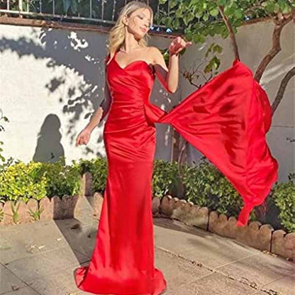 Elegant red one shoulder satin bridesmaid dress flowing in the breeze outdoors