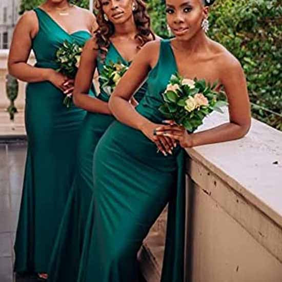Three elegant women in one shoulder satin bridesmaid dress holding bouquets, showcasing a chic wedding look