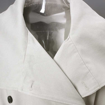 Detail of an oversize women's trench coat featuring a stylish collar and button closure