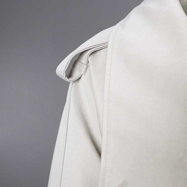 Soft beige oversize women's trench coat with stylish shoulder details and a classic silhouette