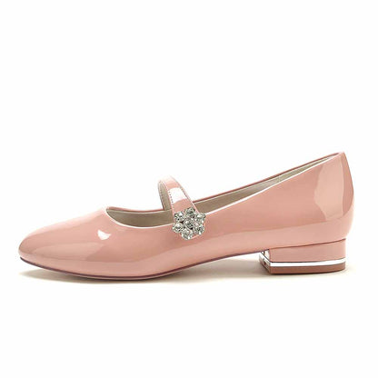Pink patent leather wedding shoes by S&DCo with a decorative flower and a low heel