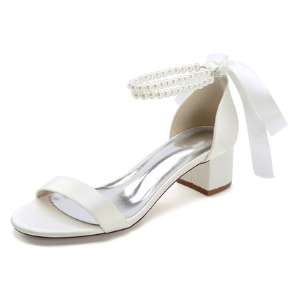 Elegant pearl lace-up bridal sandals with block heel and satin ribbon for a chic wedding look