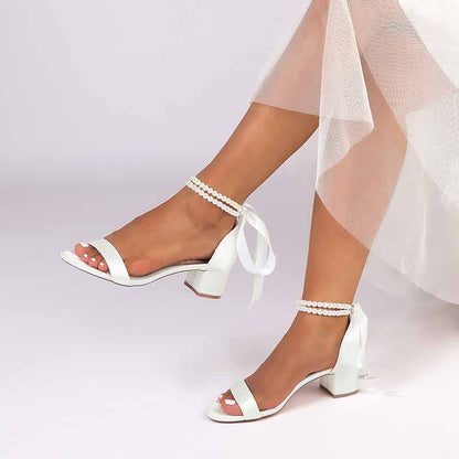 Elegant pearl lace-up bridal sandals featuring ankle straps and a stylish heel for weddings
