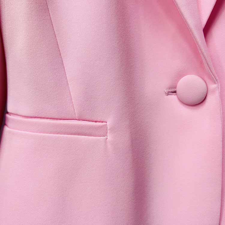 Detail of pink women's pantsuit for wedding with tailored fit and elegant button design