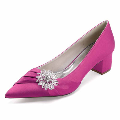Pink pointed toe wedding shoes for bride with elegant flower embellishment and low heel