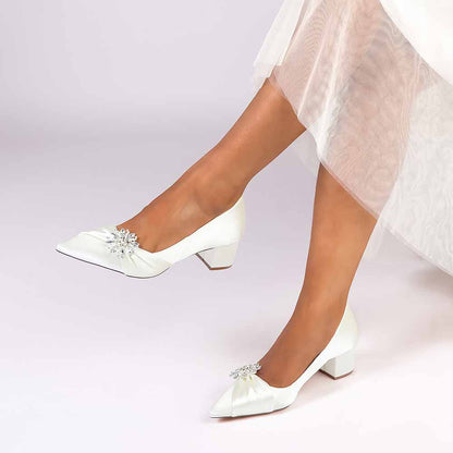 Elegant white pointed toe wedding shoes for bride with decorative embellishment and low heel