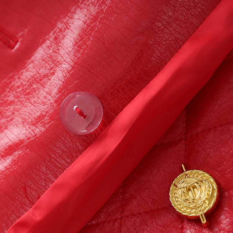 Close-up of a red faux leather mini dress featuring gold buttons and detailed stitching
