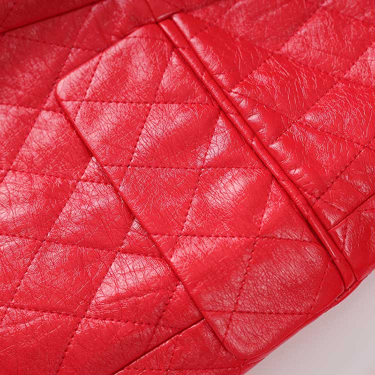 Close-up of red faux leather mini dress featuring a quilted texture and stylish pocket detail