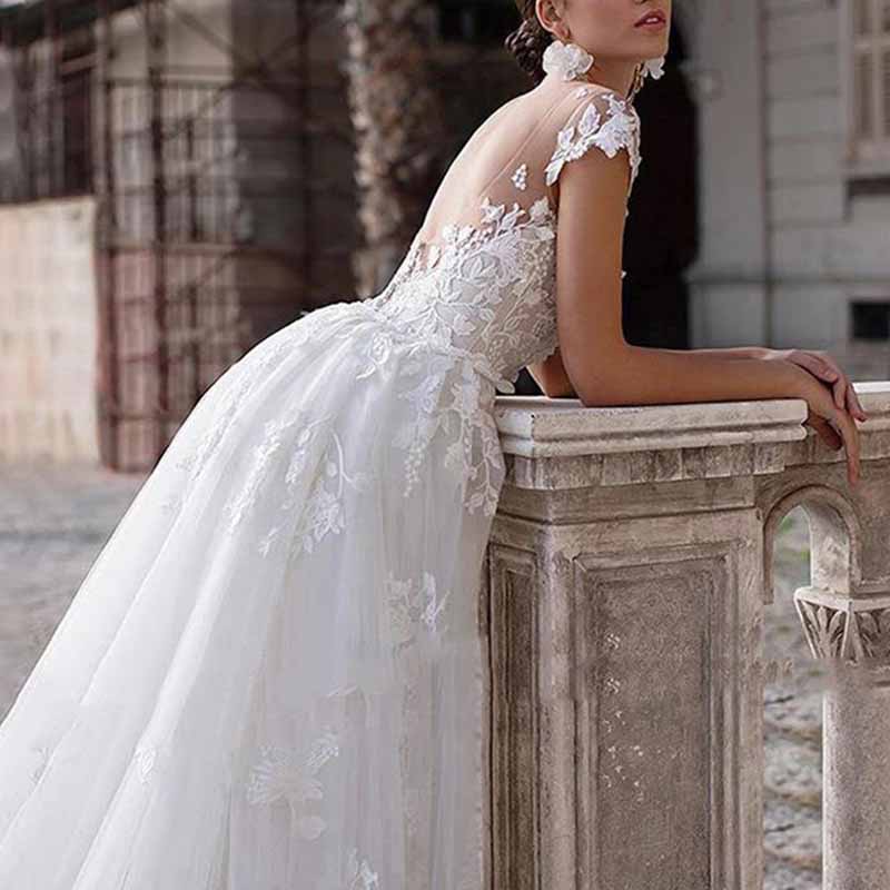 Stunning romantic lace wedding dress with sleeves featuring intricate embroidery and a flowing skirt