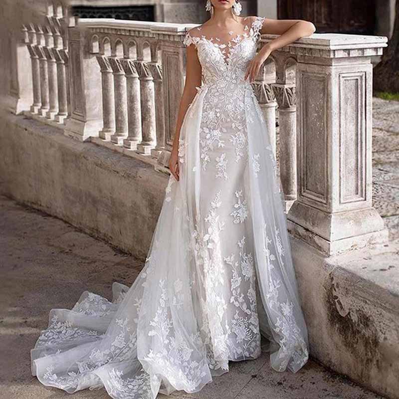 Elegant romantic lace wedding dress with sleeves featuring floral appliques and a flowing train
