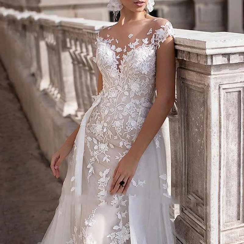 Elegant romantic lace wedding dress with sleeves featuring intricate floral embroidery and a flowing silhouette
