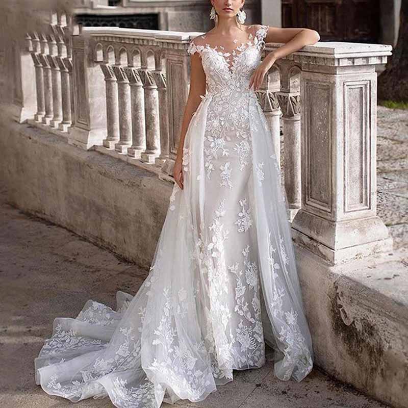 Stunning romantic lace wedding dress with sleeves featuring detailed floral designs and a flowing train