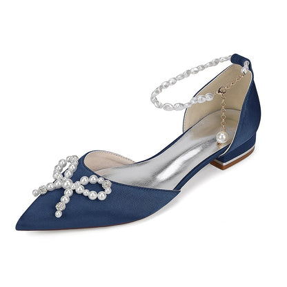 Satin bridal flats with pearls featuring a bow and ankle strap for elegant wedding attire