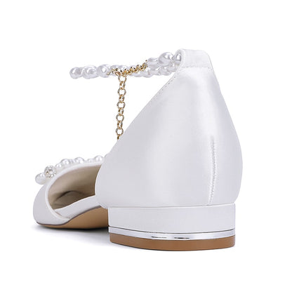 Satin bridal flats with pearls featuring an elegant ankle strap and a low heel for comfort on your wedding day