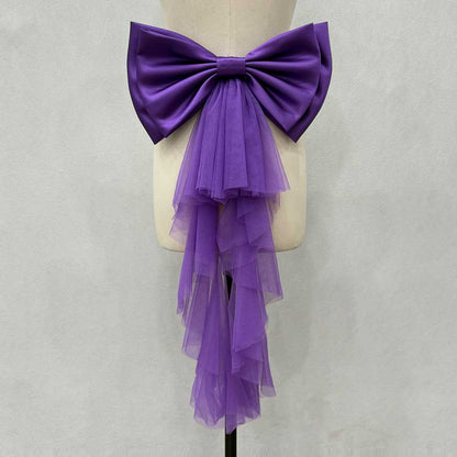 Purple satin wedding bow for bridal dress with layered tulle tails arranged on a display mannequin
