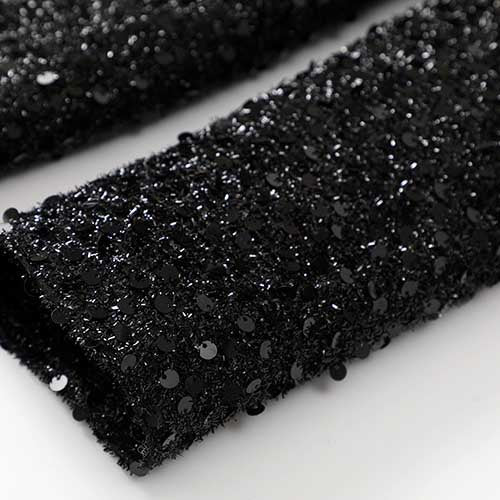 Close-up of a sparkly party blazer for women featuring shimmering black sequins on a soft fabric