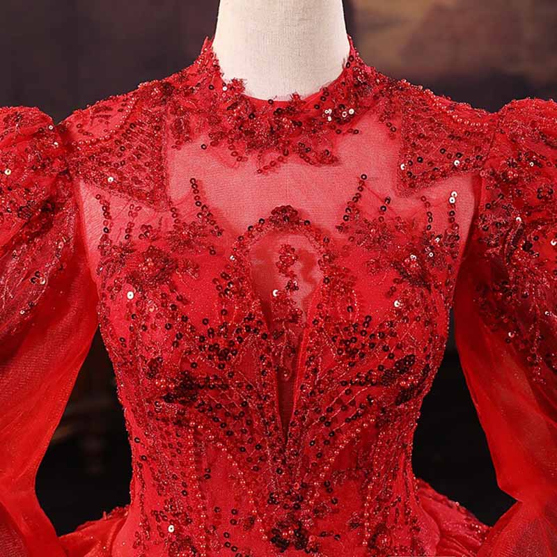 Elegant sparkly red ball gown wedding dress with intricate beading and dramatic puff sleeves
