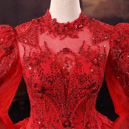 Elegant sparkly red ball gown wedding dress with intricate beading and dramatic puff sleeves