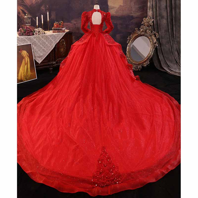 Elegant sparkly red ball gown wedding dress with intricate detail and dramatic train