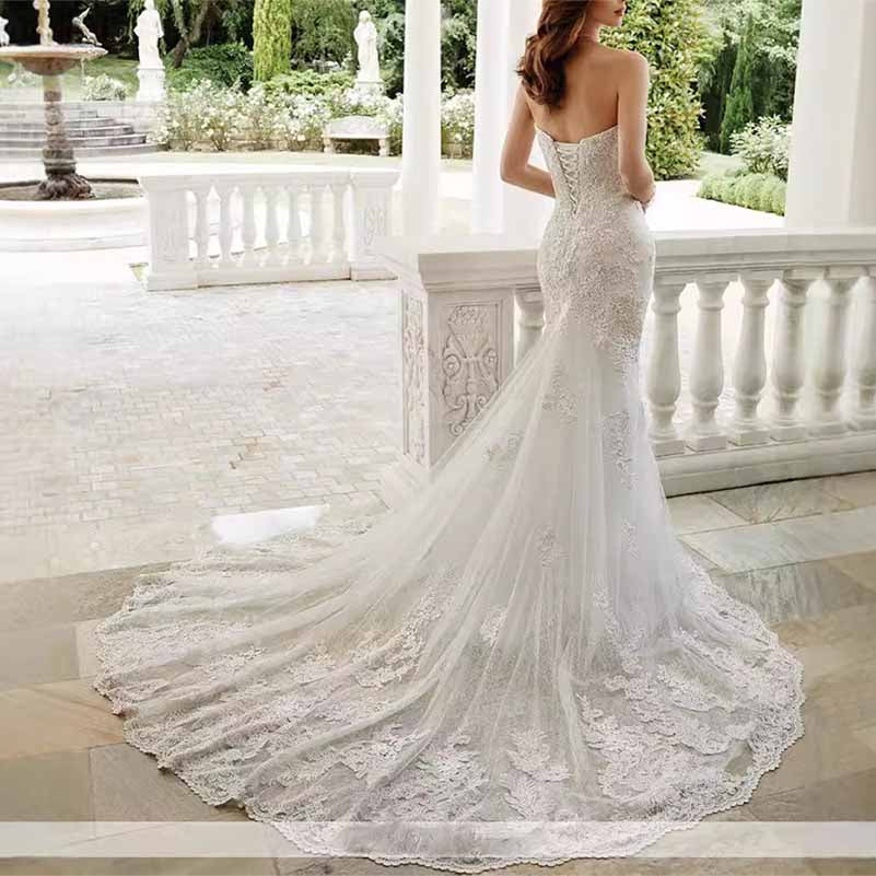 Elegant strapless lace mermaid wedding dress with a stunning trailing train and detailed lace design.