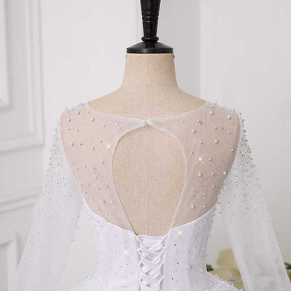 Elegant sweetheart tulle wedding dress featuring a beaded back and long sheer sleeves