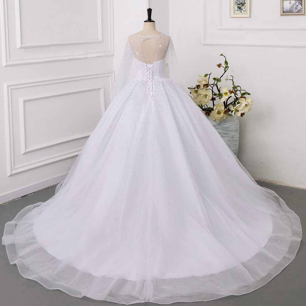 Elegant sweetheart tulle wedding dress with long sleeves and a flowing skirt for a fairy tale bridal look